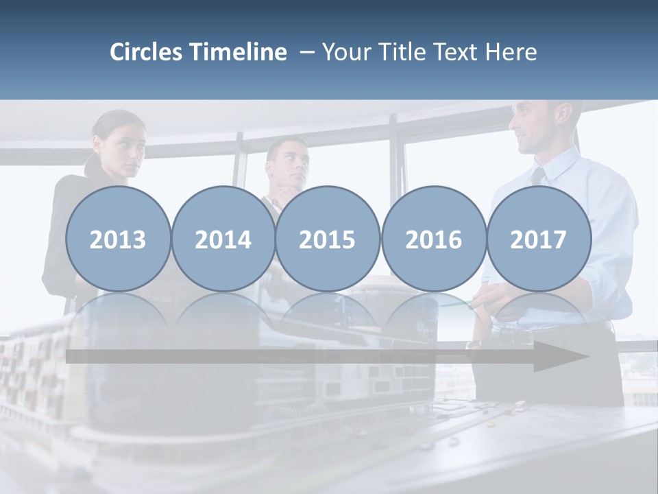 A Group Of People Standing Around A Model Of A Building PowerPoint Template