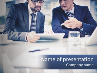 Two Men Sitting At A Table Looking At A Tablet PowerPoint Template
