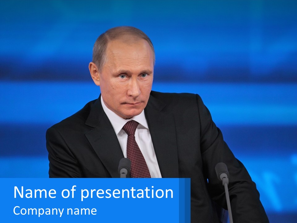 A Man In A Suit And Tie Sitting At A Table PowerPoint Template