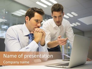 Two Men Sitting At A Table Looking At A Laptop PowerPoint Template