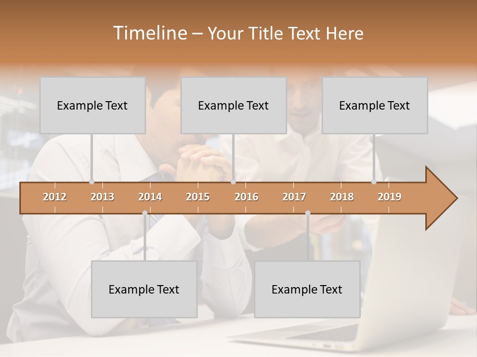 Two Men Sitting At A Table Looking At A Laptop PowerPoint Template
