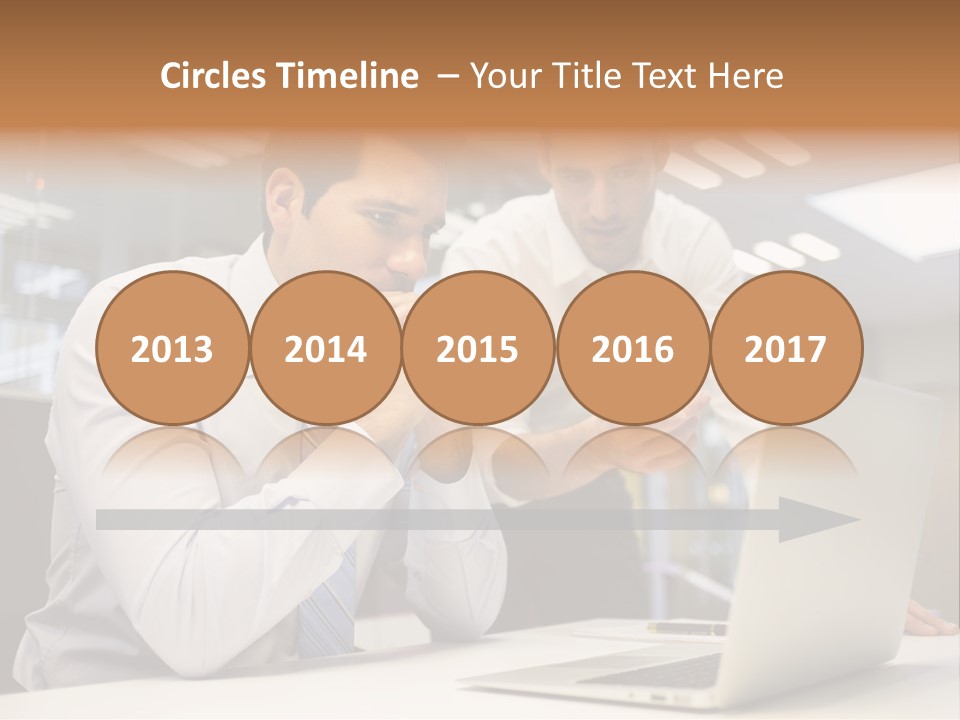 Two Men Sitting At A Table Looking At A Laptop PowerPoint Template