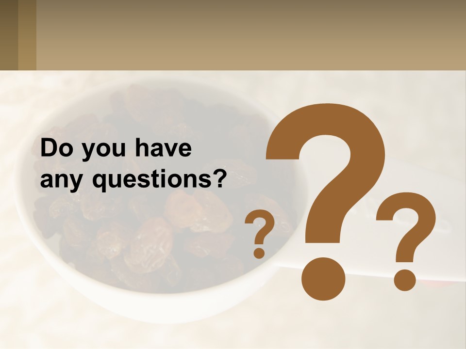 A White Spoon Filled With Raisins On Top Of A Table PowerPoint Template