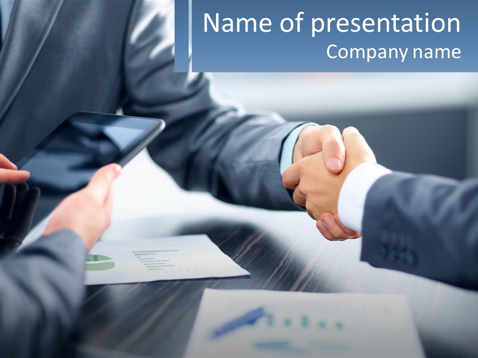Two Business People Shaking Hands Over A Table PowerPoint Template