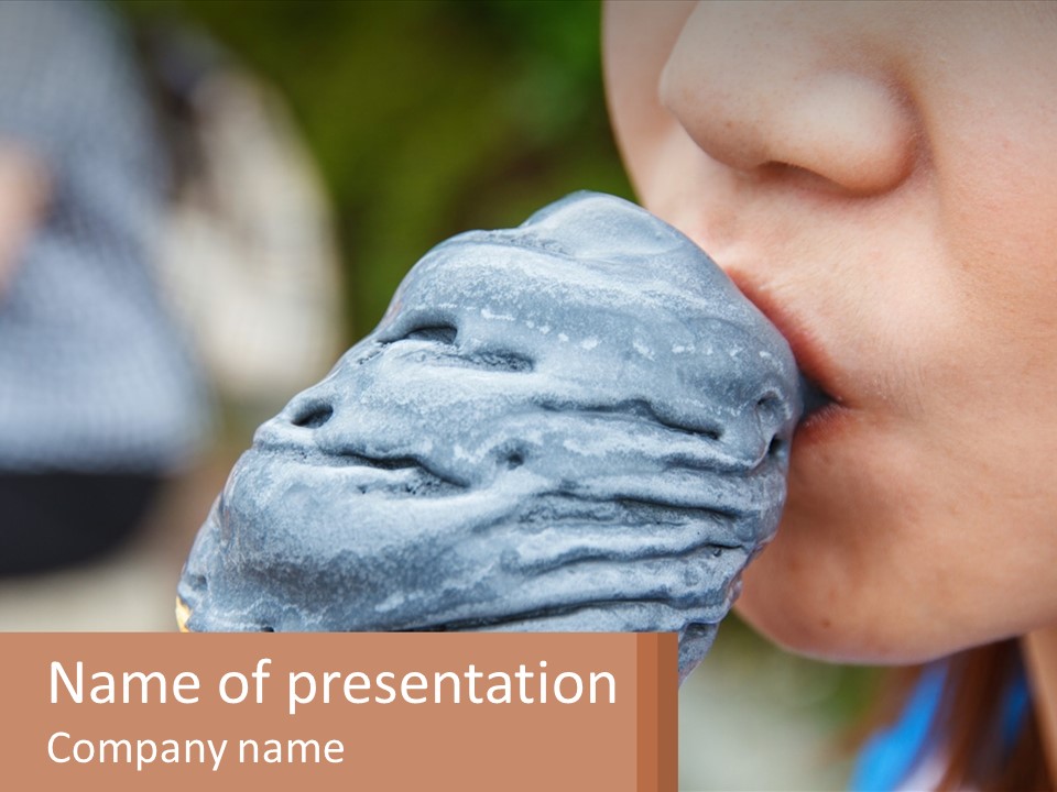 A Child Is Eating A Piece Of Blue Ice Cream PowerPoint Template
