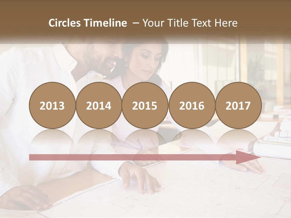 A Man And Woman Sitting At A Desk In An Office PowerPoint Template