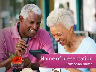 A Man And Woman Sitting At A Table Looking At A Tablet PowerPoint Template