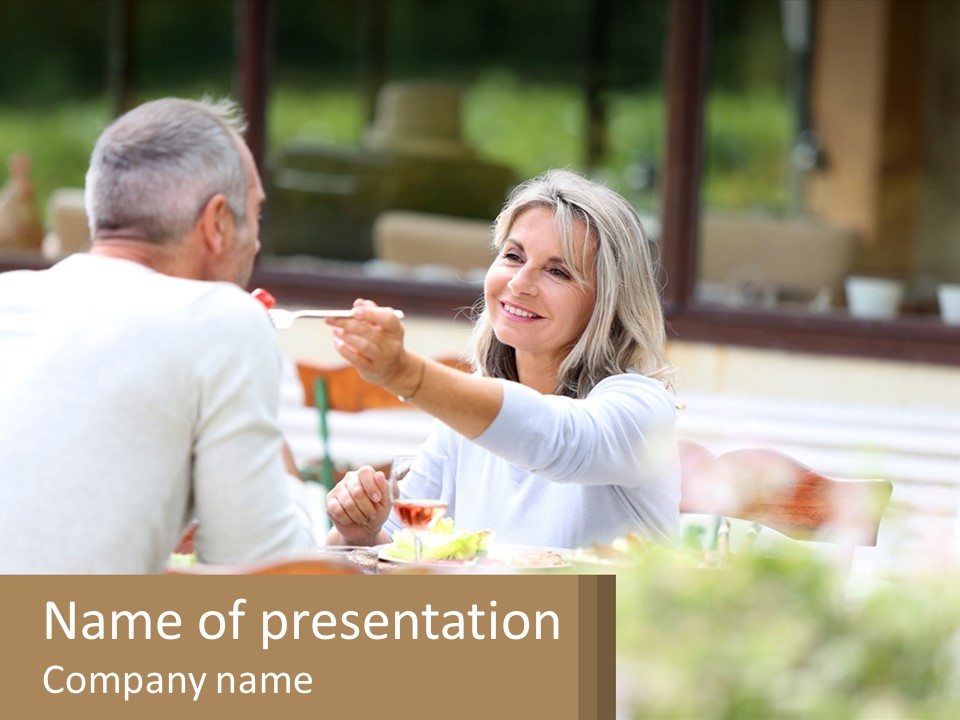 A Man And A Woman Sitting At A Table Eating Food PowerPoint Template
