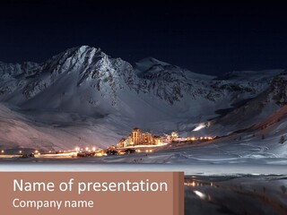 A Snowy Mountain With A Town Lit Up At Night PowerPoint Template