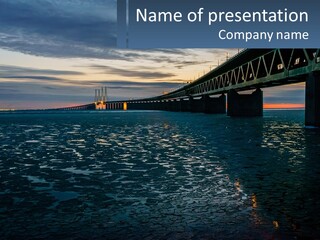A Bridge Over A Body Of Water At Sunset PowerPoint Template