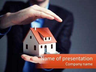 A Person Holding A Small Model House In Their Hands PowerPoint Template
