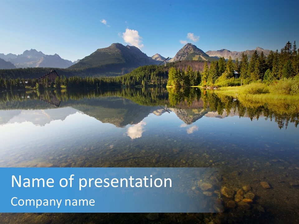 A Lake With Mountains In The Background And A Blue Sky PowerPoint Template