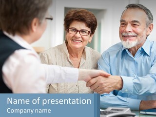 A Couple Of People Shaking Hands Over A Desk PowerPoint Template