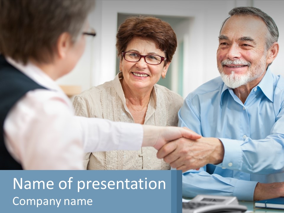 A Couple Of People Shaking Hands Over A Desk PowerPoint Template