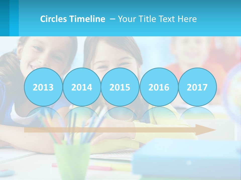 Two Young Girls Are Sitting At A Desk With Pencils PowerPoint Template