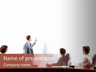 A Group Of People Sitting Around A Conference Table PowerPoint Template