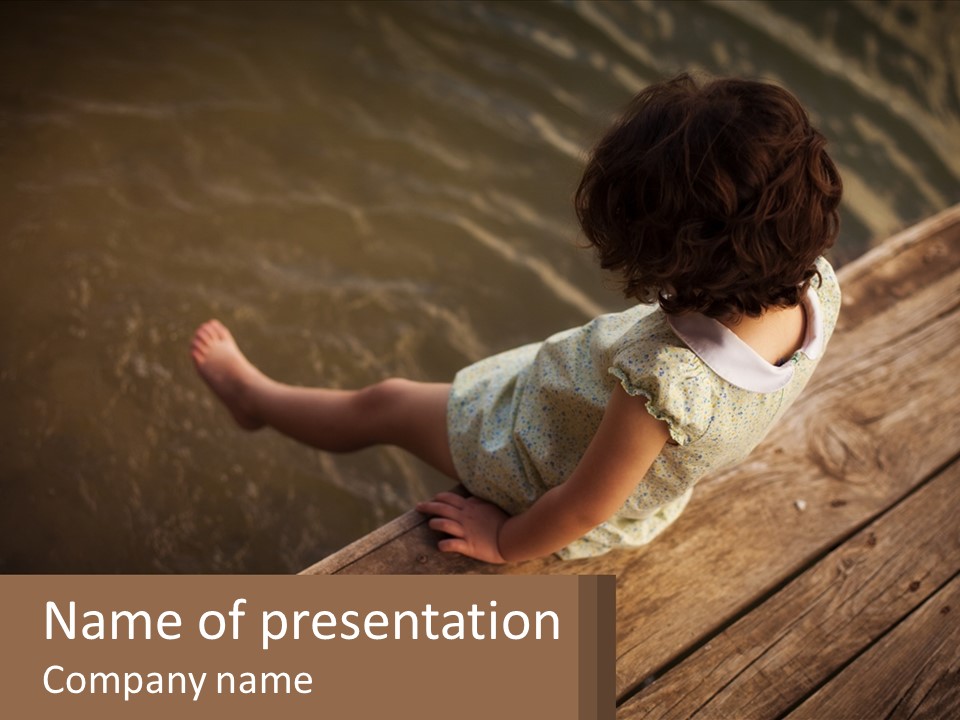 A Little Girl Sitting On A Dock Looking At The Water PowerPoint Template