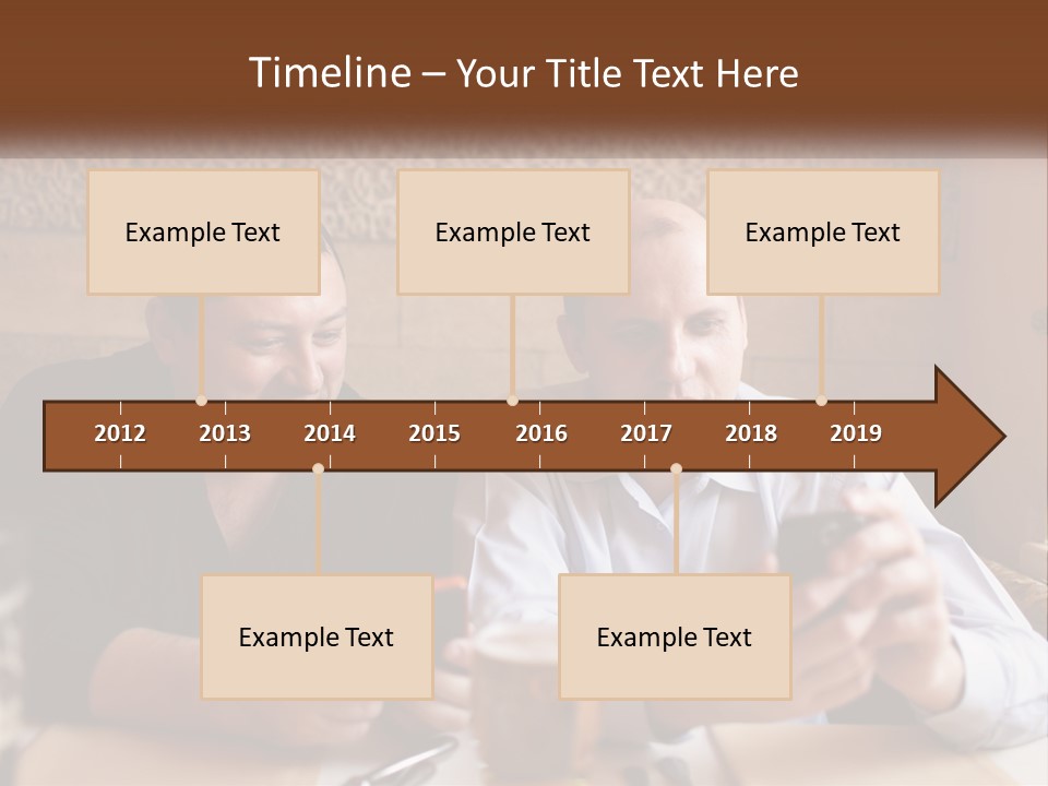 Two Men Sitting At A Table Looking At A Cell Phone PowerPoint Template