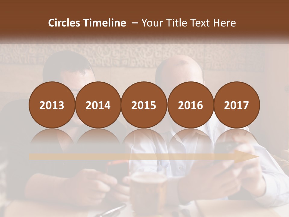 Two Men Sitting At A Table Looking At A Cell Phone PowerPoint Template