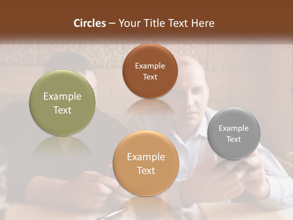 Two Men Sitting At A Table Looking At A Cell Phone PowerPoint Template