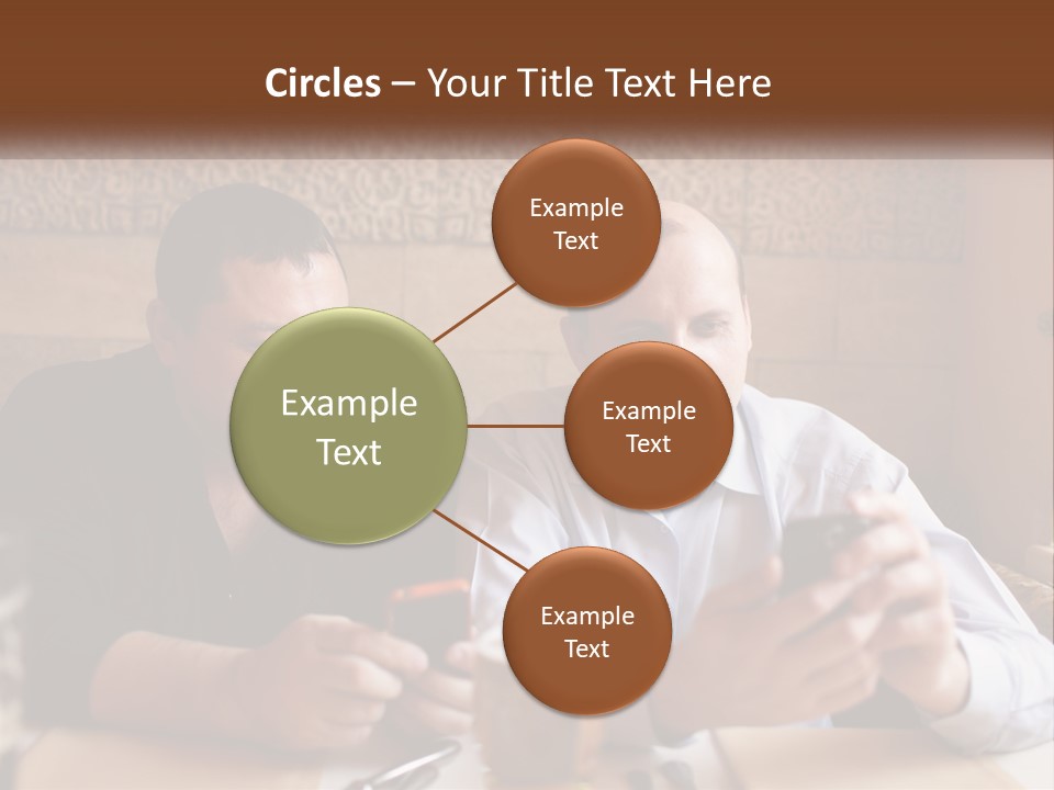 Two Men Sitting At A Table Looking At A Cell Phone PowerPoint Template