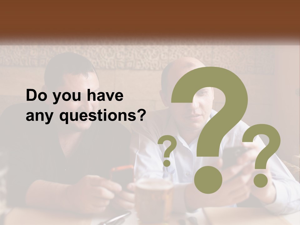 Two Men Sitting At A Table Looking At A Cell Phone PowerPoint Template