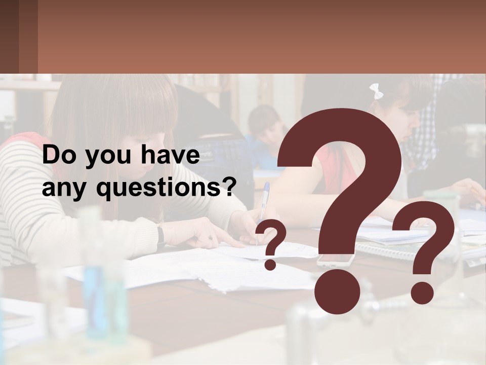A Group Of People Sitting At A Table Writing PowerPoint Template