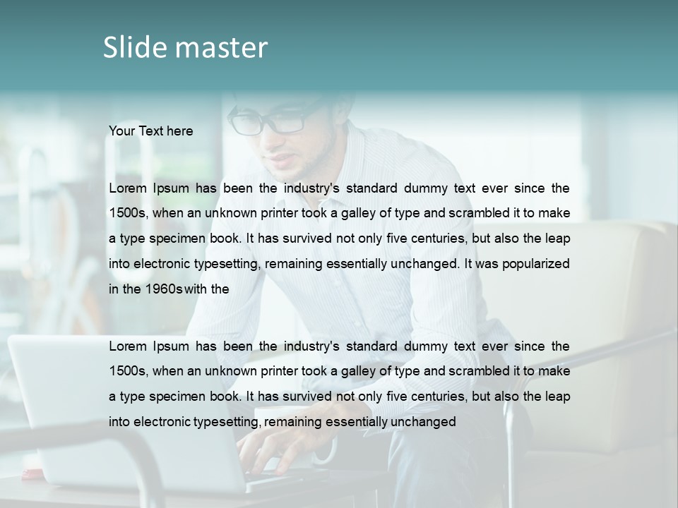 A Man Sitting At A Table Using A Laptop Computer PowerPoint Template