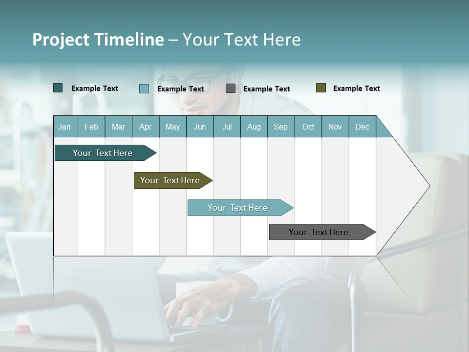 A Man Sitting At A Table Using A Laptop Computer PowerPoint Template