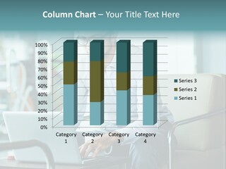 A Man Sitting At A Table Using A Laptop Computer PowerPoint Template