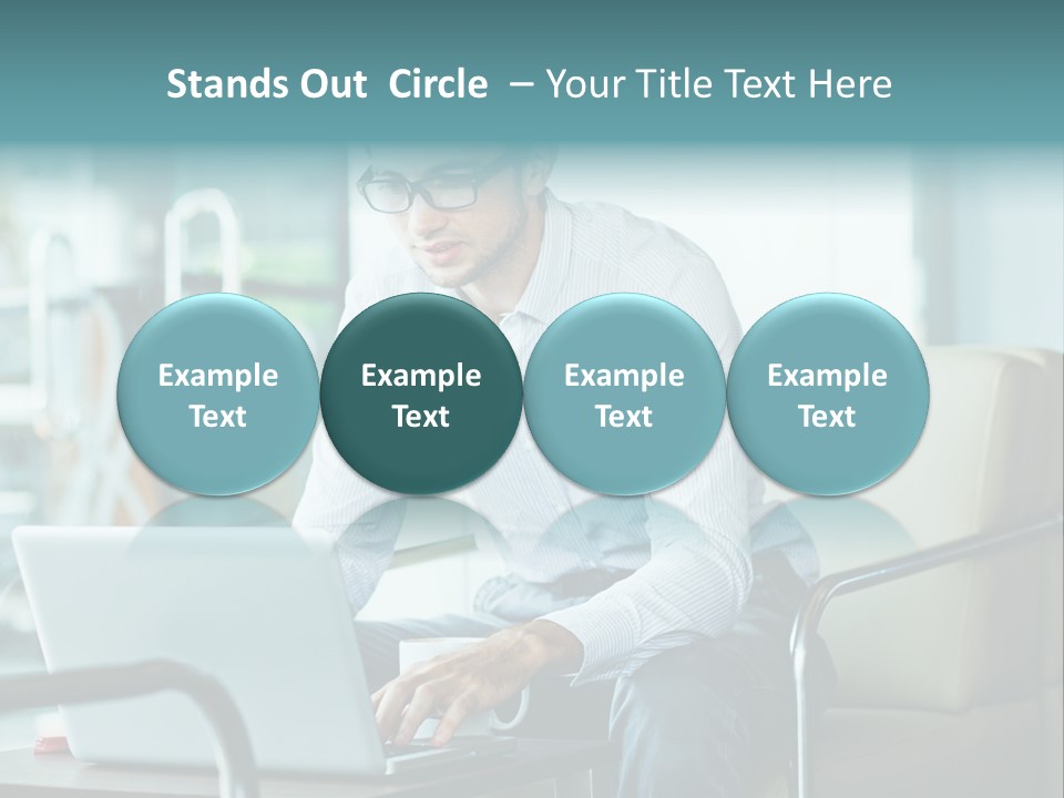 A Man Sitting At A Table Using A Laptop Computer PowerPoint Template