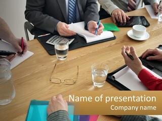 A Group Of People Sitting Around A Wooden Table PowerPoint Template