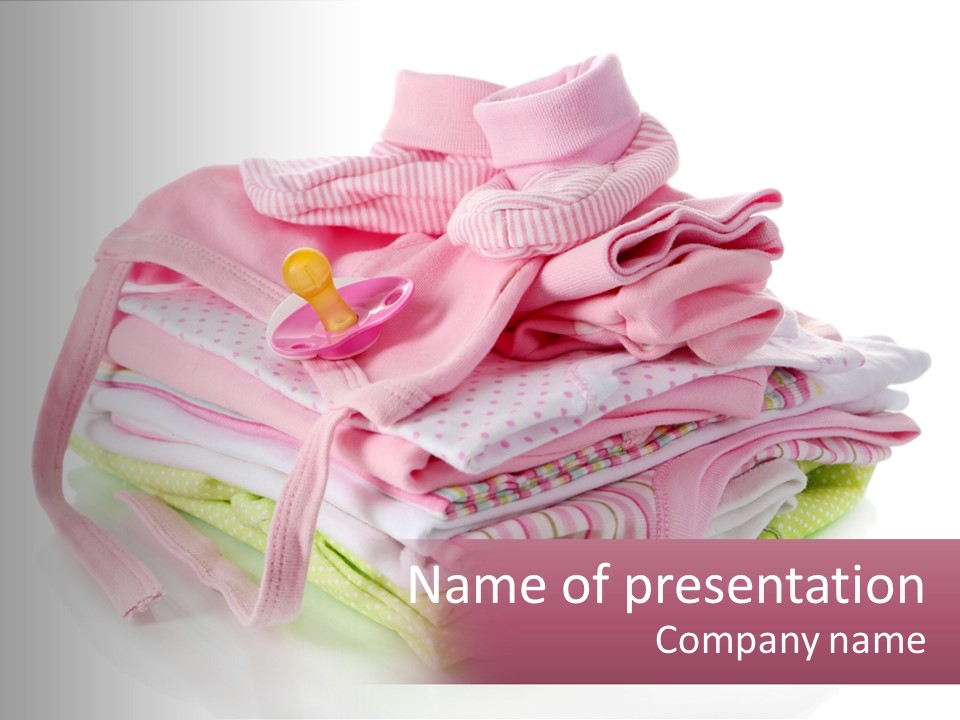 A Pile Of Baby Clothes With A Pacifier On Top Of It PowerPoint Template