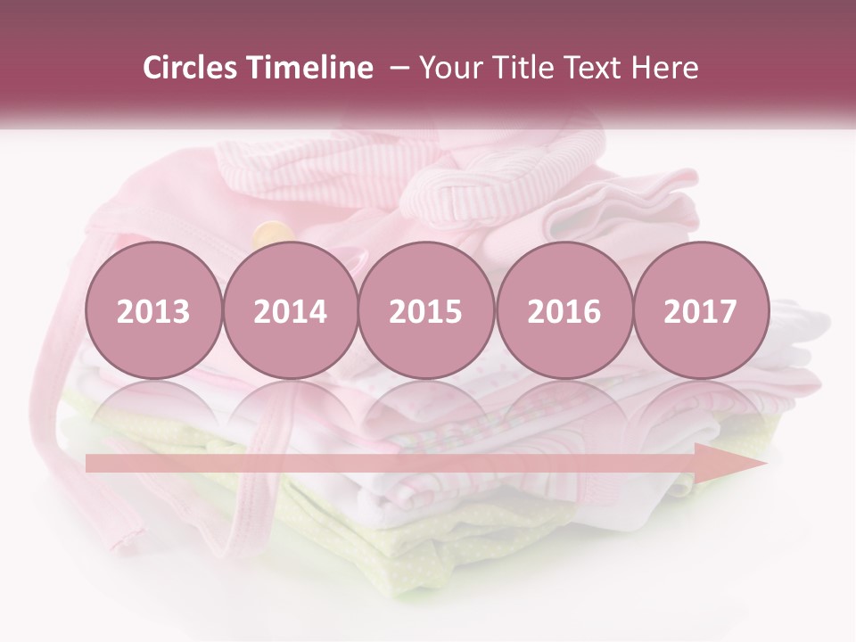 A Pile Of Baby Clothes With A Pacifier On Top Of It PowerPoint Template