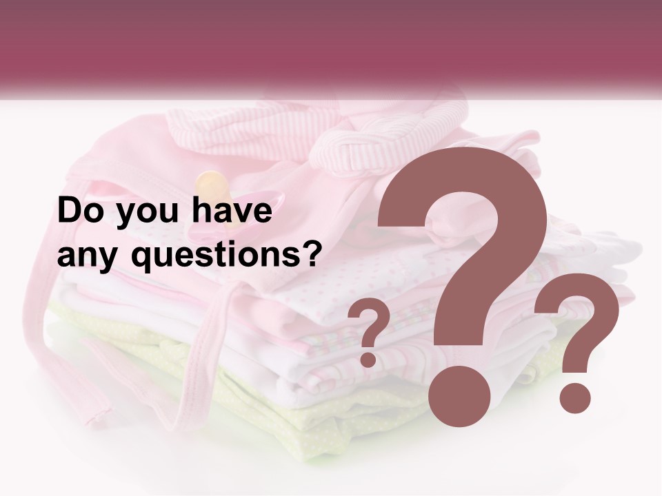 A Pile Of Baby Clothes With A Pacifier On Top Of It PowerPoint Template