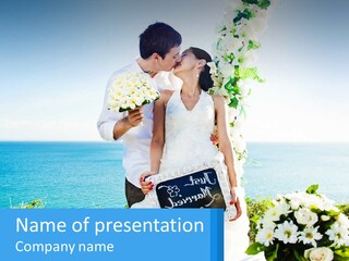 A Newly Married Couple Kissing In Front Of The Ocean PowerPoint Template