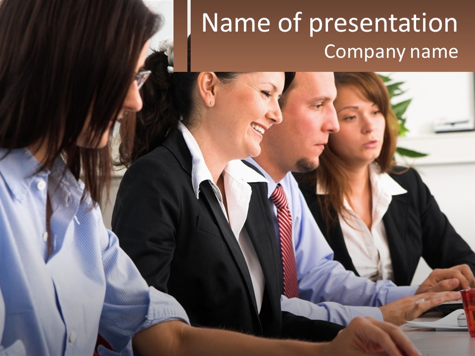 A Group Of People Sitting At A Table Working On A Computer PowerPoint Template