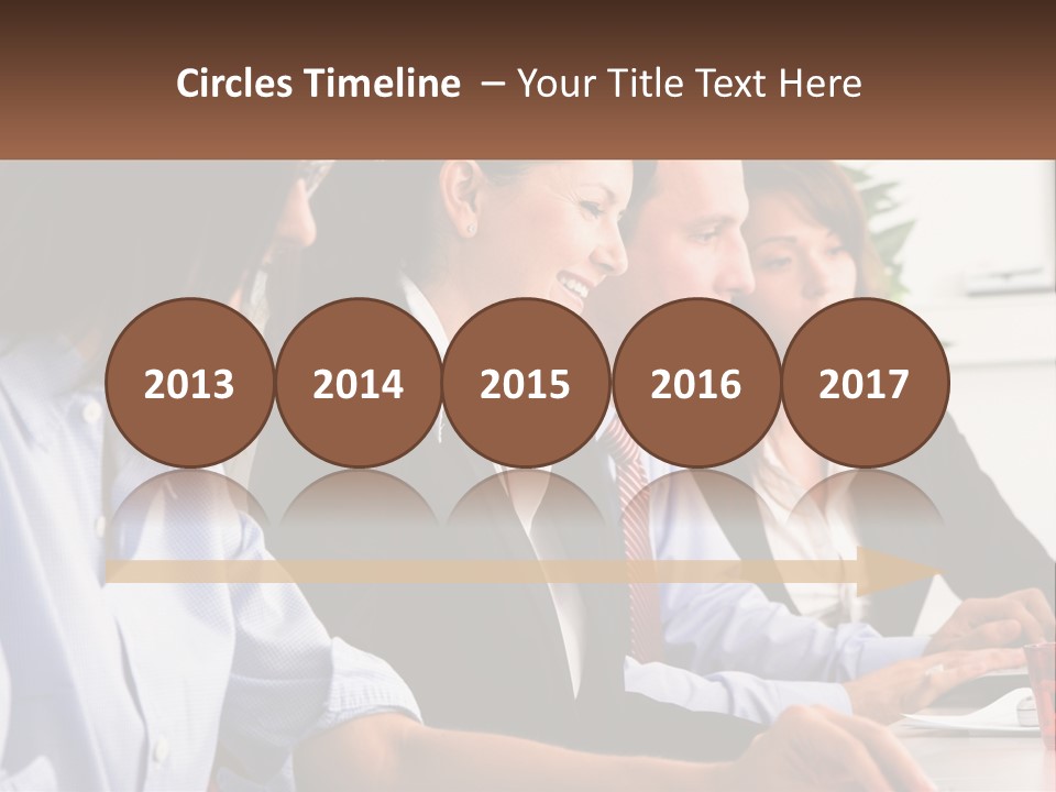 A Group Of People Sitting At A Table Working On A Computer PowerPoint Template