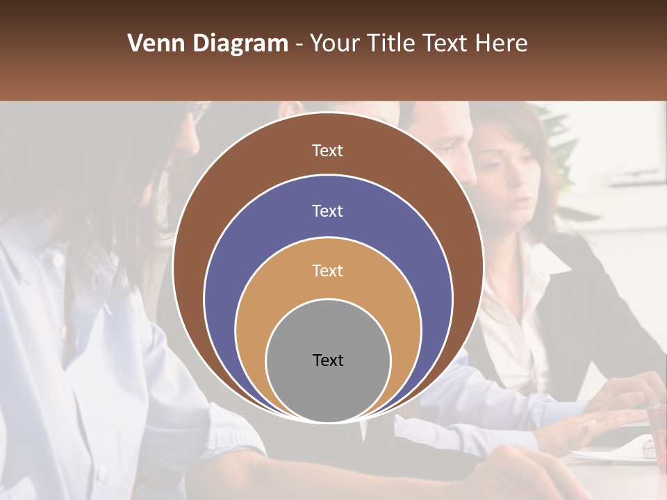 A Group Of People Sitting At A Table Working On A Computer PowerPoint Template